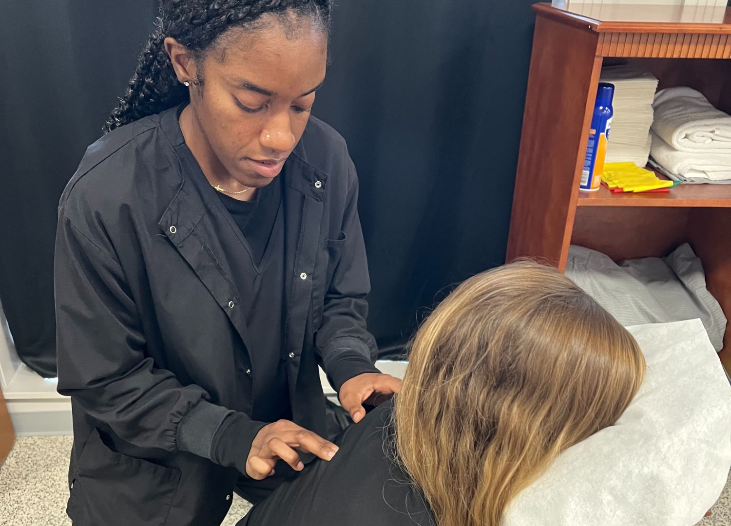 Chiropractor performing spinal adjustment on female patient